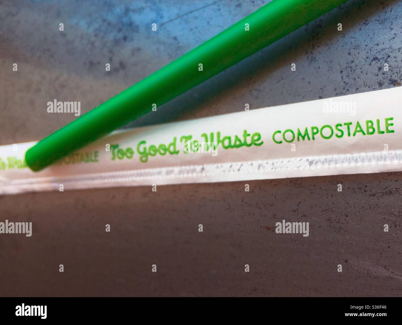 Close up of too good to waste brand of PLA compostable green straw and wrapper , USA - Smartphone Captured Stock Image