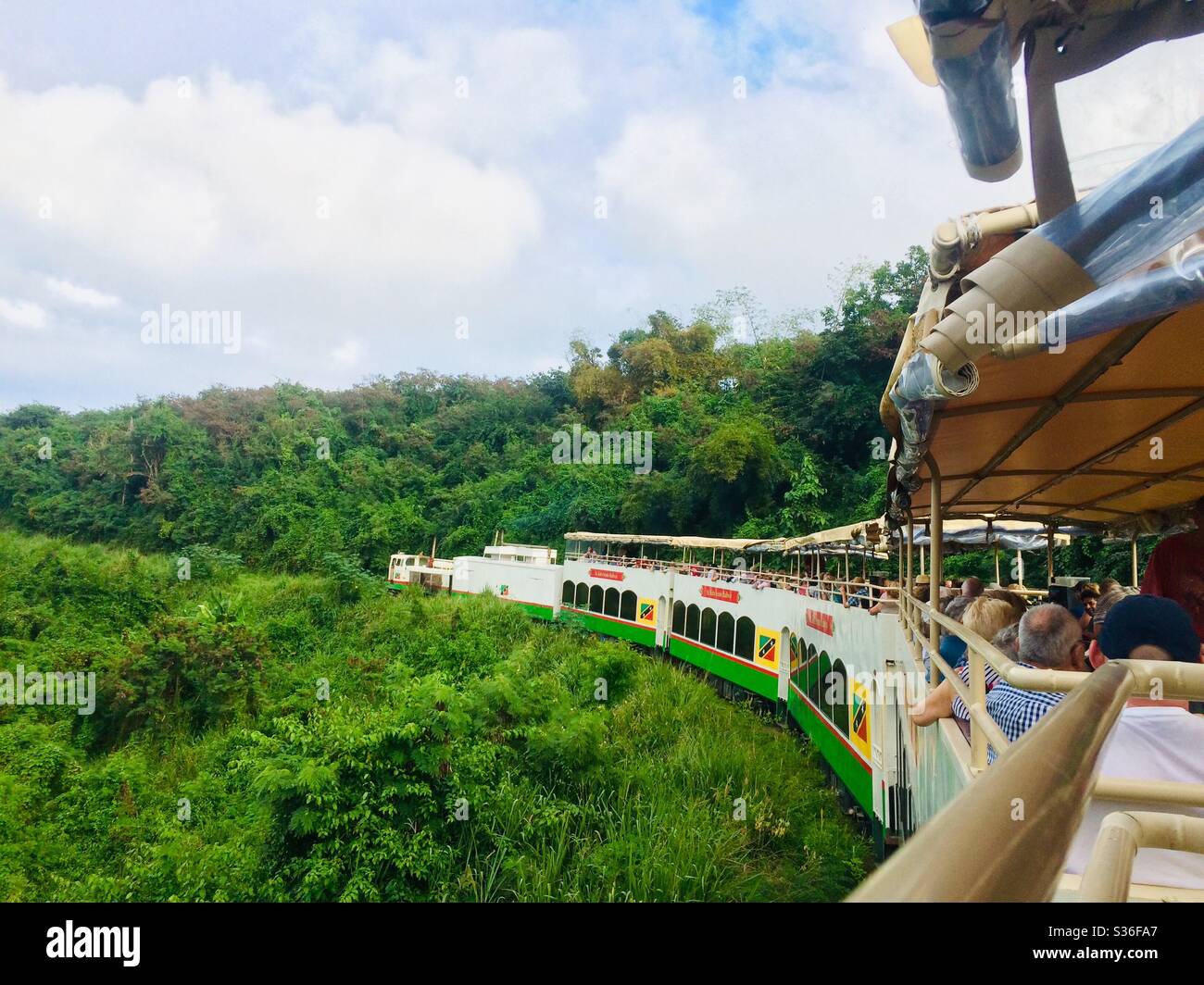 Tourist train travels through the lush hills of St. Kitts in the Caribbean Stock Photo