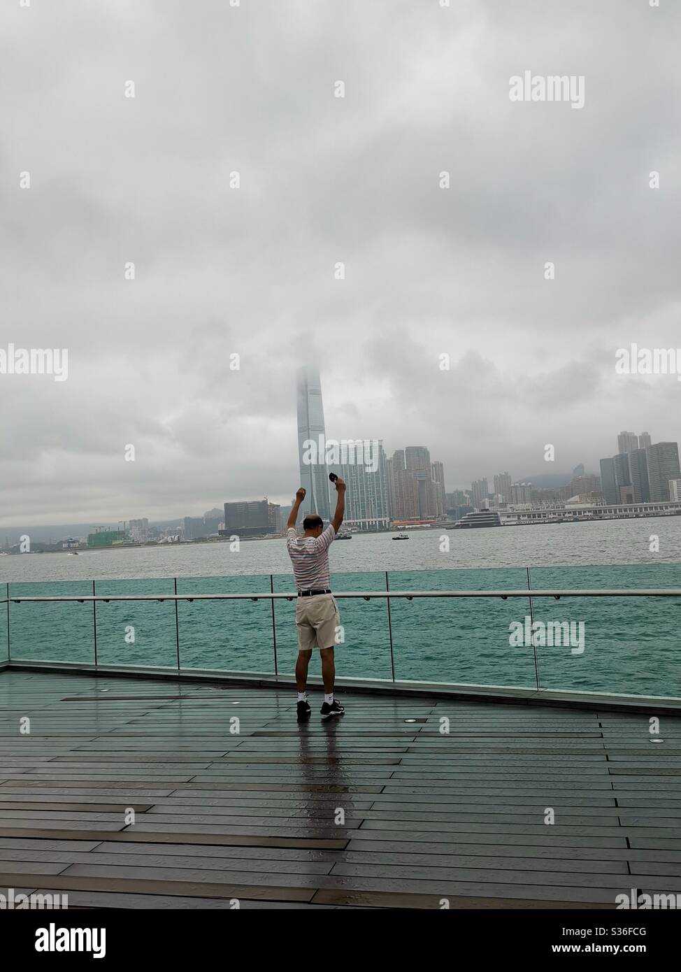 Morning exercise in front of the Victoria harbour in Hong Kong. - Smartphone Captured Stock Image