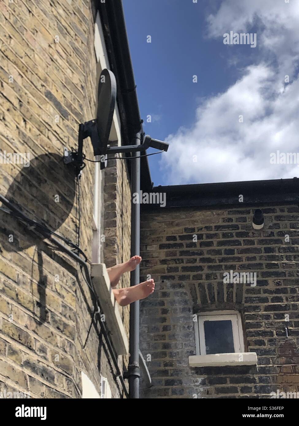 23/05/2020 anonymous a person’s  feet seen outside their window as they try to take advantage of sunny weather while lockdown restrictions in place in London UK due to Covid-19 Pandemic - Smartphone Captured Stock Image