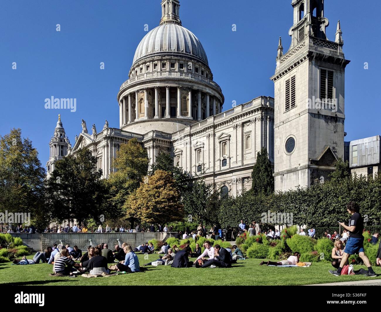 St.Pauls cathedral ground with hundreds of people enjoying Sun during lunchtime Stock Photo