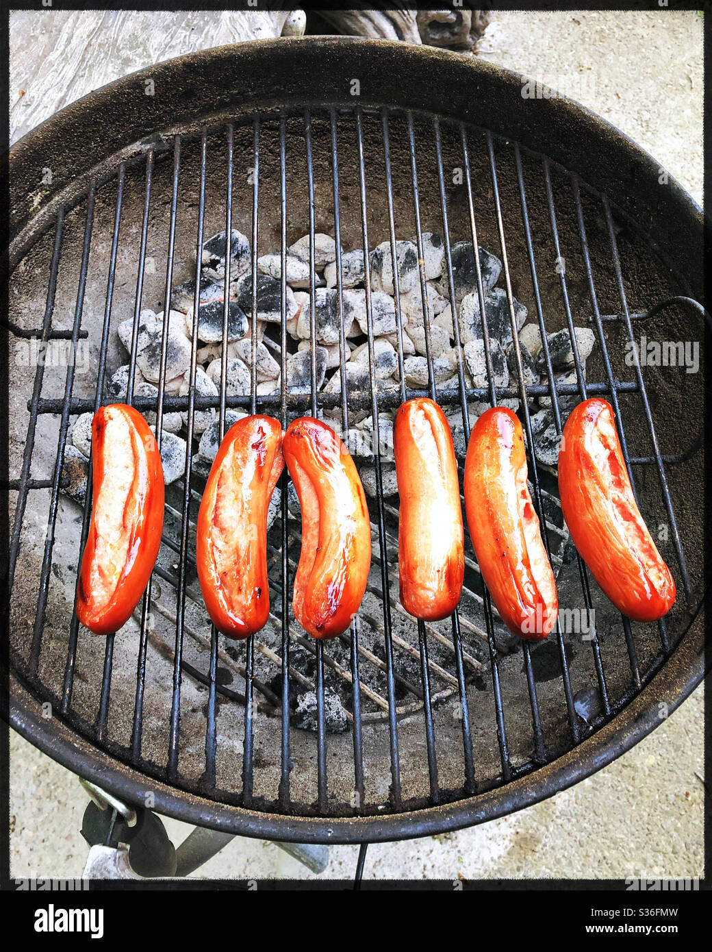 Hotdogs cooking on charcoal grill Stock Photo Alamy