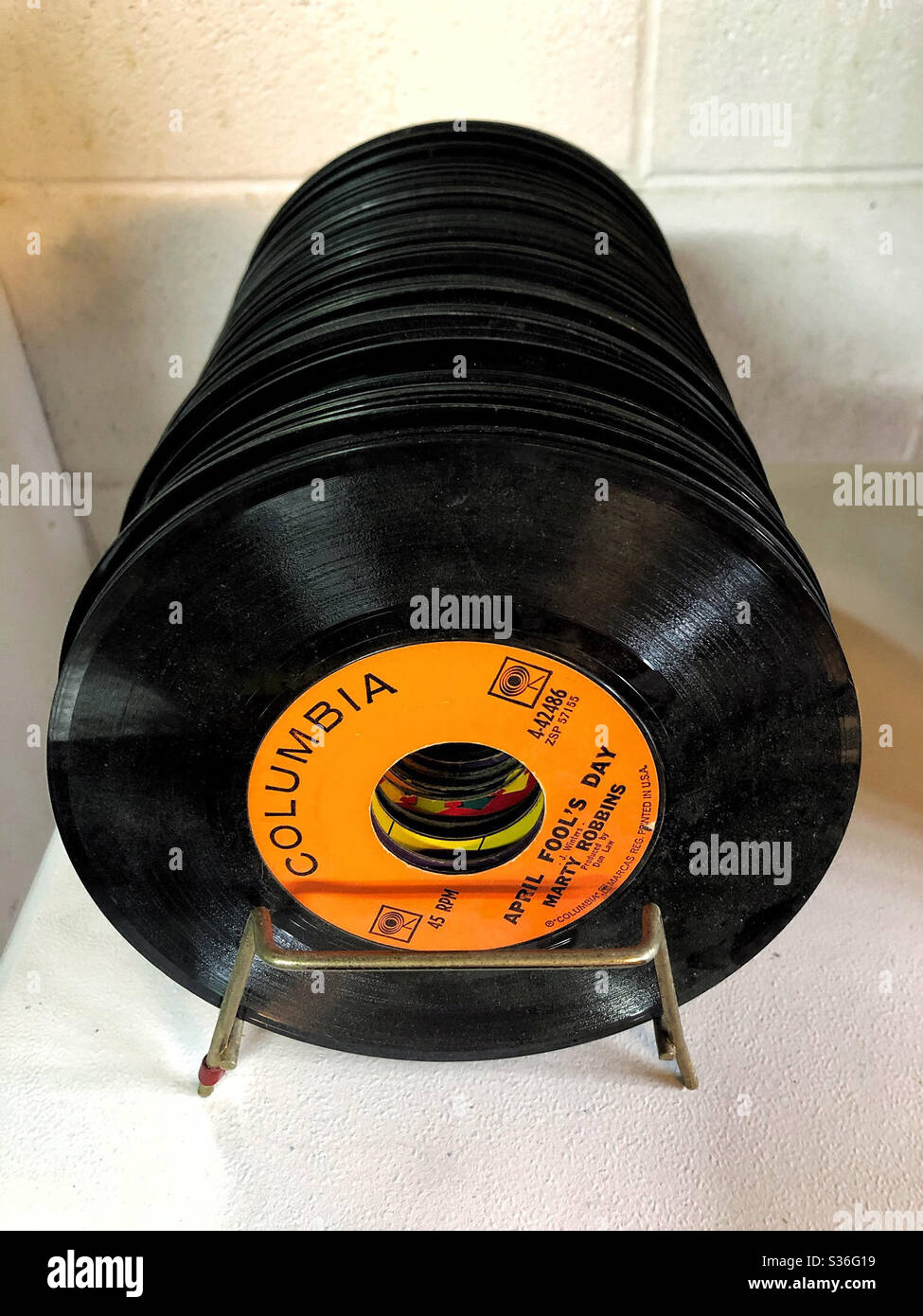 Record rack holding a group of vintage 45 rpm black records Stock Photo