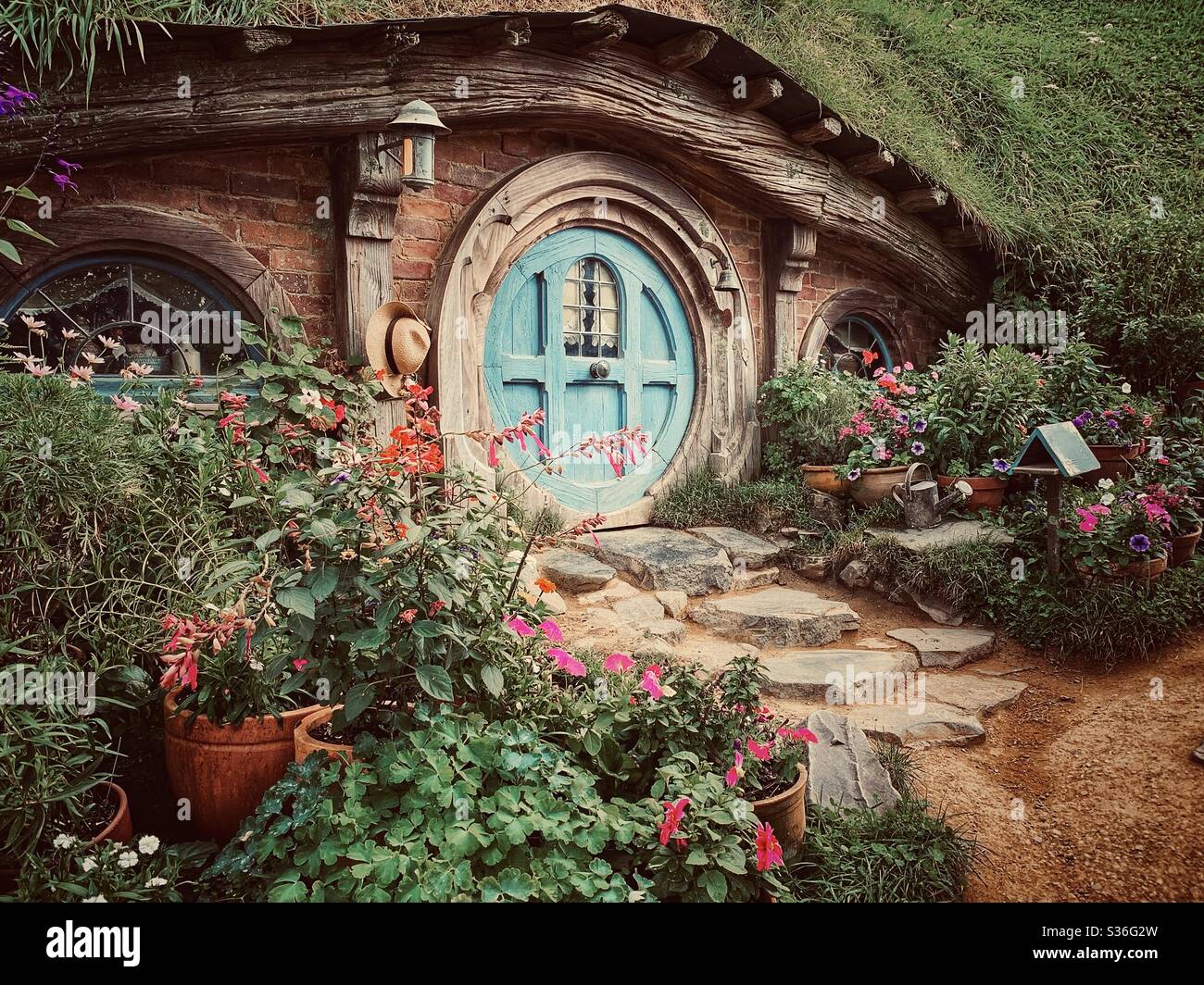 Hobbiton. Bucolic place in New Zealand where the hobbits from the Middle Earth live. Lord of the rings movie set. Blue round shape door Stock Photo