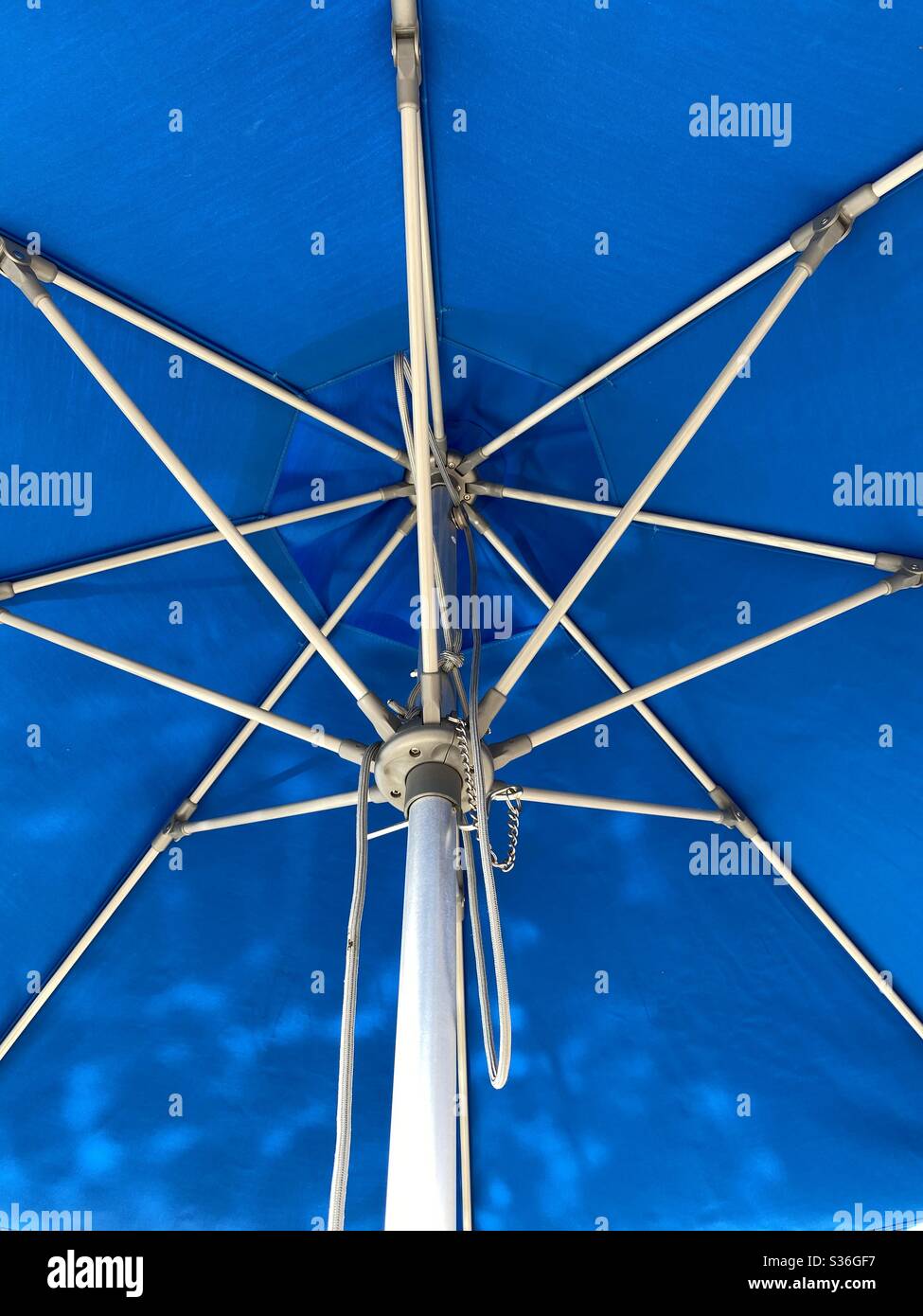 Underside of a bright blue outdoor umbrella - Smartphone Captured Stock Image