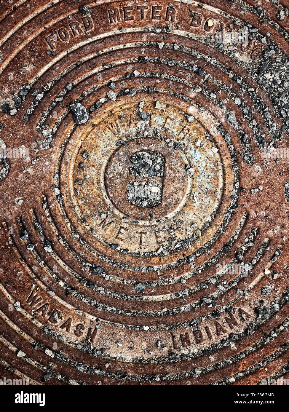 An overhead view of a metal cover on a water meter - Smartphone Captured Stock Image