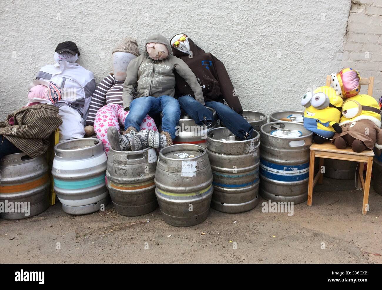 Drunken scarecrows sitting on top of empty beer kegs. Stock Photo