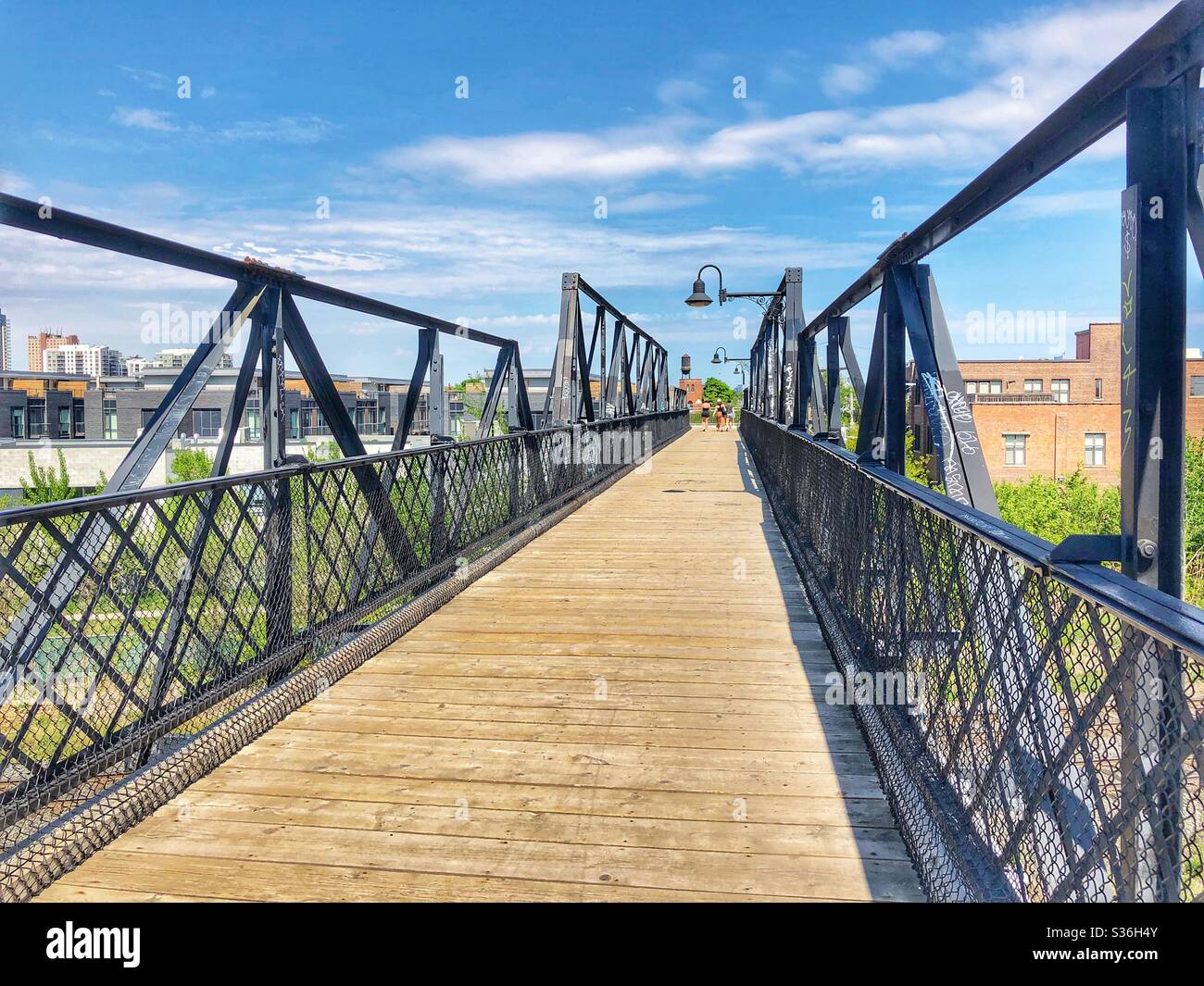 Walking over a wooden and metal bridge. Stock Photo