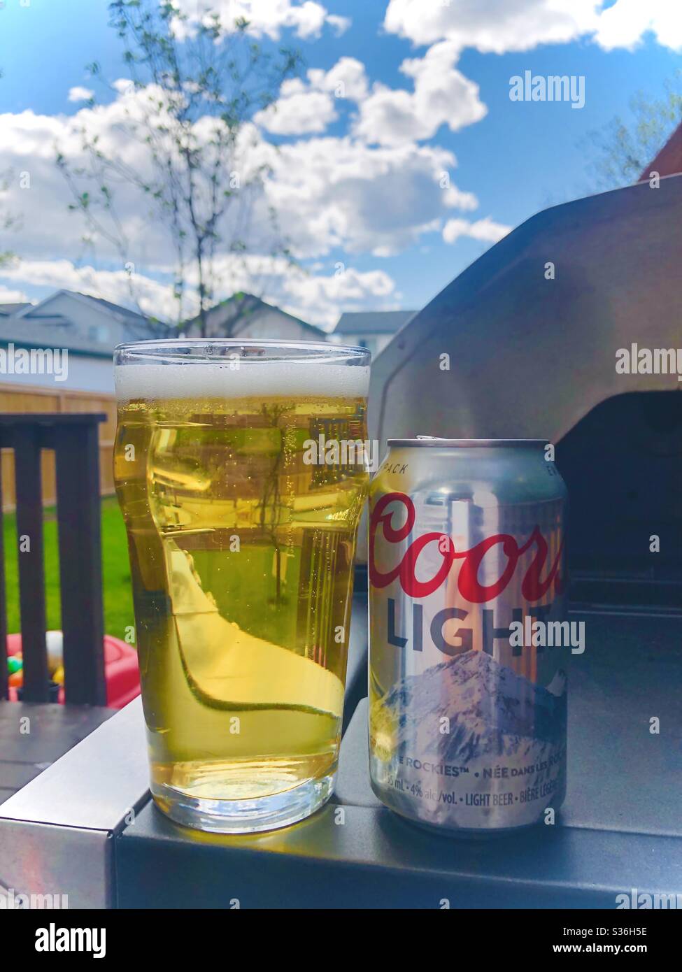 Pint of beer with a Coors Light can beer during the spring day Stock