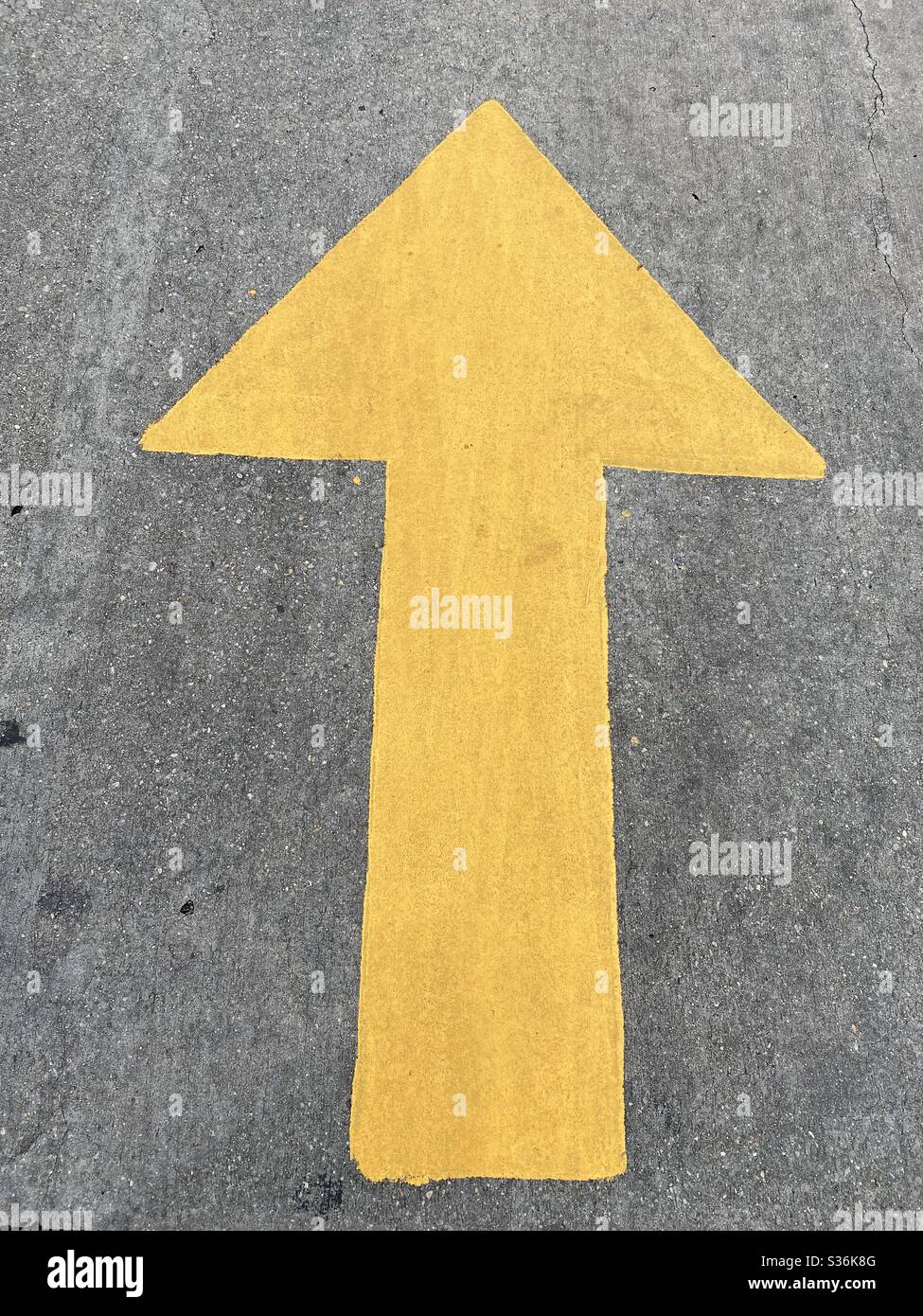 Large yellow arrow painted on asphalt on the street Stock Photo - Alamy