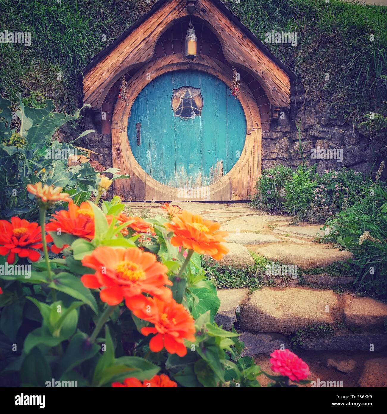 Blue round shaped door. Hobbiton. Bucolic place in New Zealand where the hobbits from the Middle Earth live. Lord of the rings movie set. Stock Photo