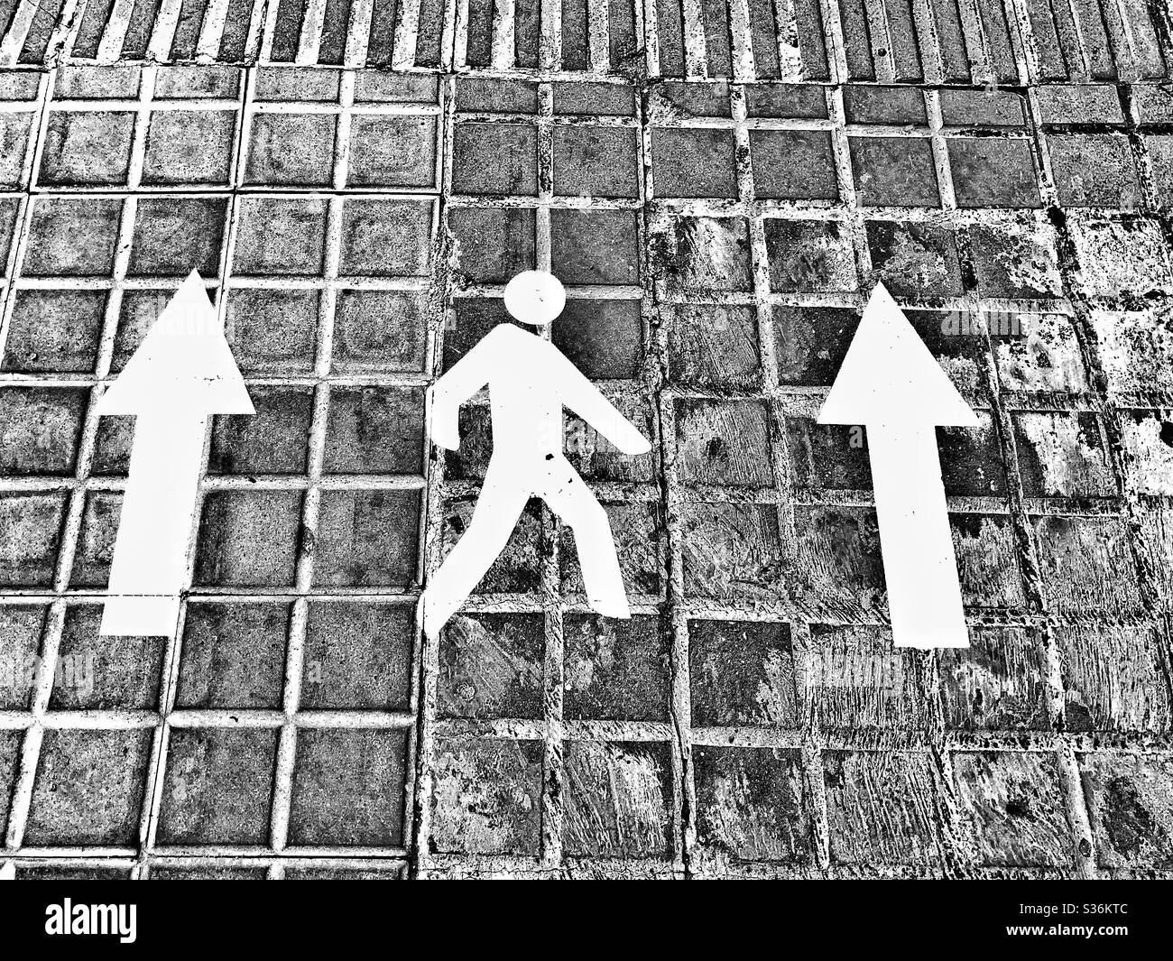 Pedestrian and arrows signs on pavement calling for people to keep right as a measure against spreading of covid-19 Stock Photo