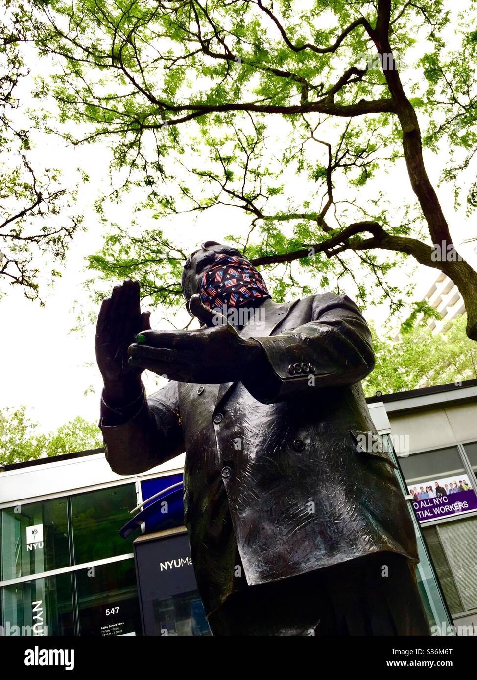 Statue of Fiorello LaGuardia with a patriotic Coronavirus mask during the pandemic on LaGuardia Place, New York City, US Stock Photo