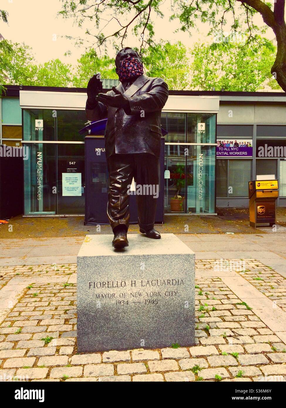 Statue of Fiorello H LaGuardia wearing a patriotic face mask during the pandemic on LaGuardia Place, New York City, USA - Smartphone Captured Stock Image