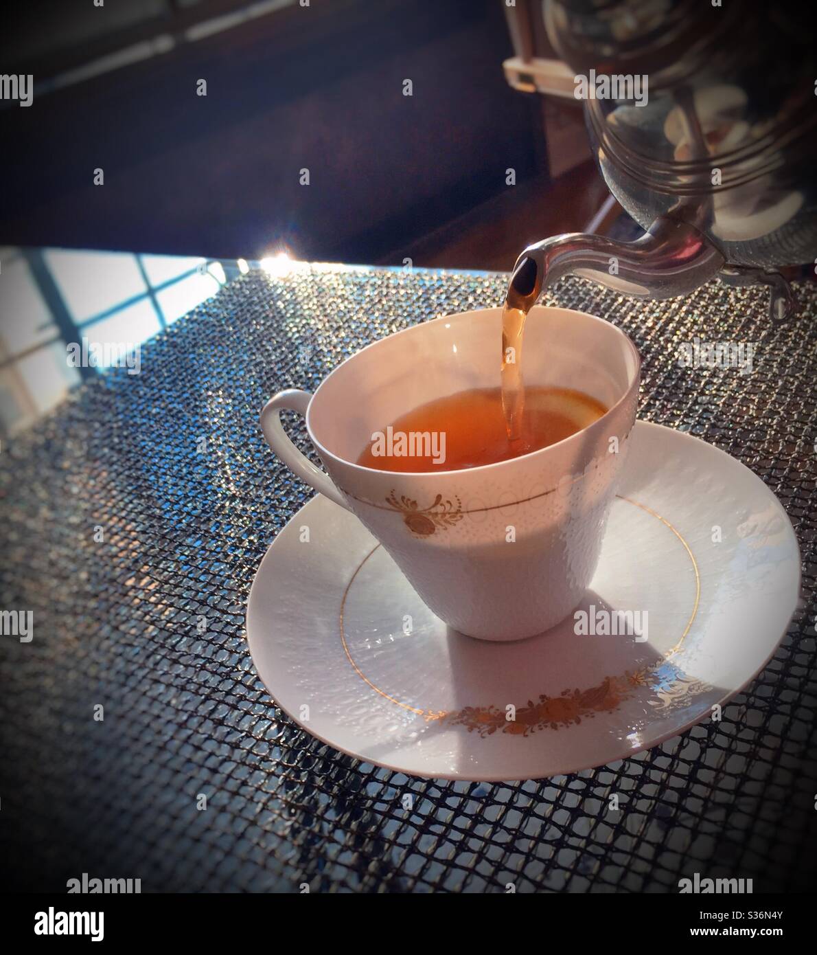 Hot tea being poured into a Rosenthal china pick up during high tea - Smartphone Captured Stock Image