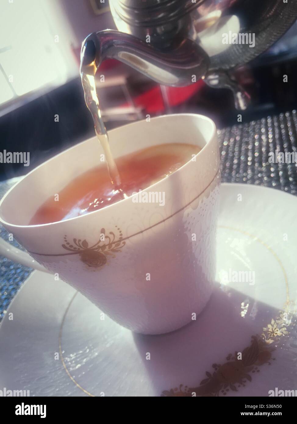 Hot tea pouring into a fine Rosenthal China teacup. - Smartphone Captured Stock Image