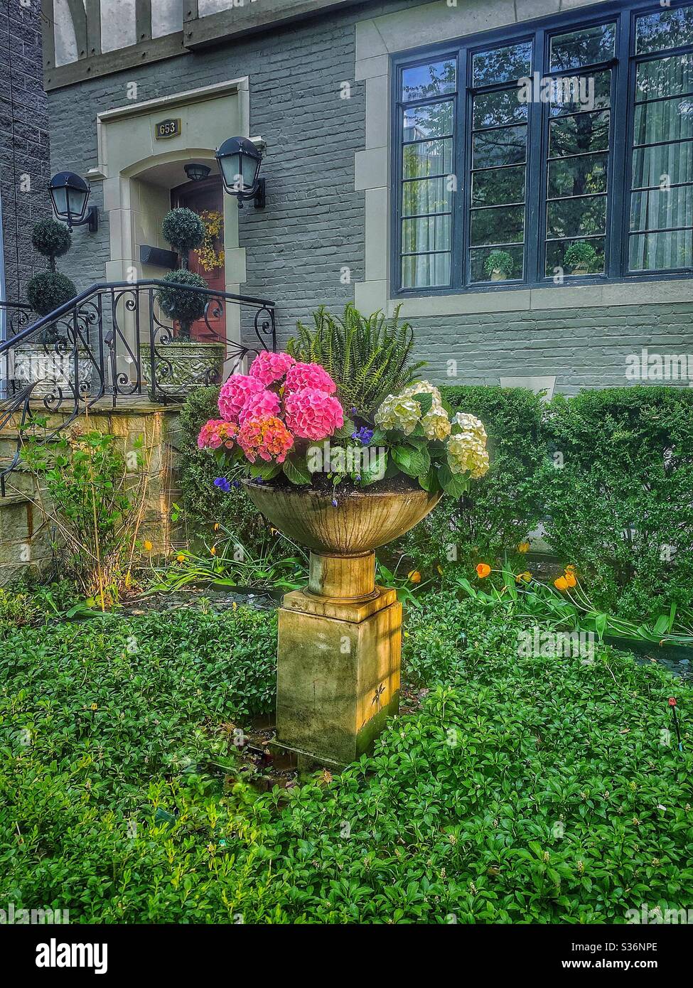 Beautiful front lawn garden with flowers in front of a house, Chicago