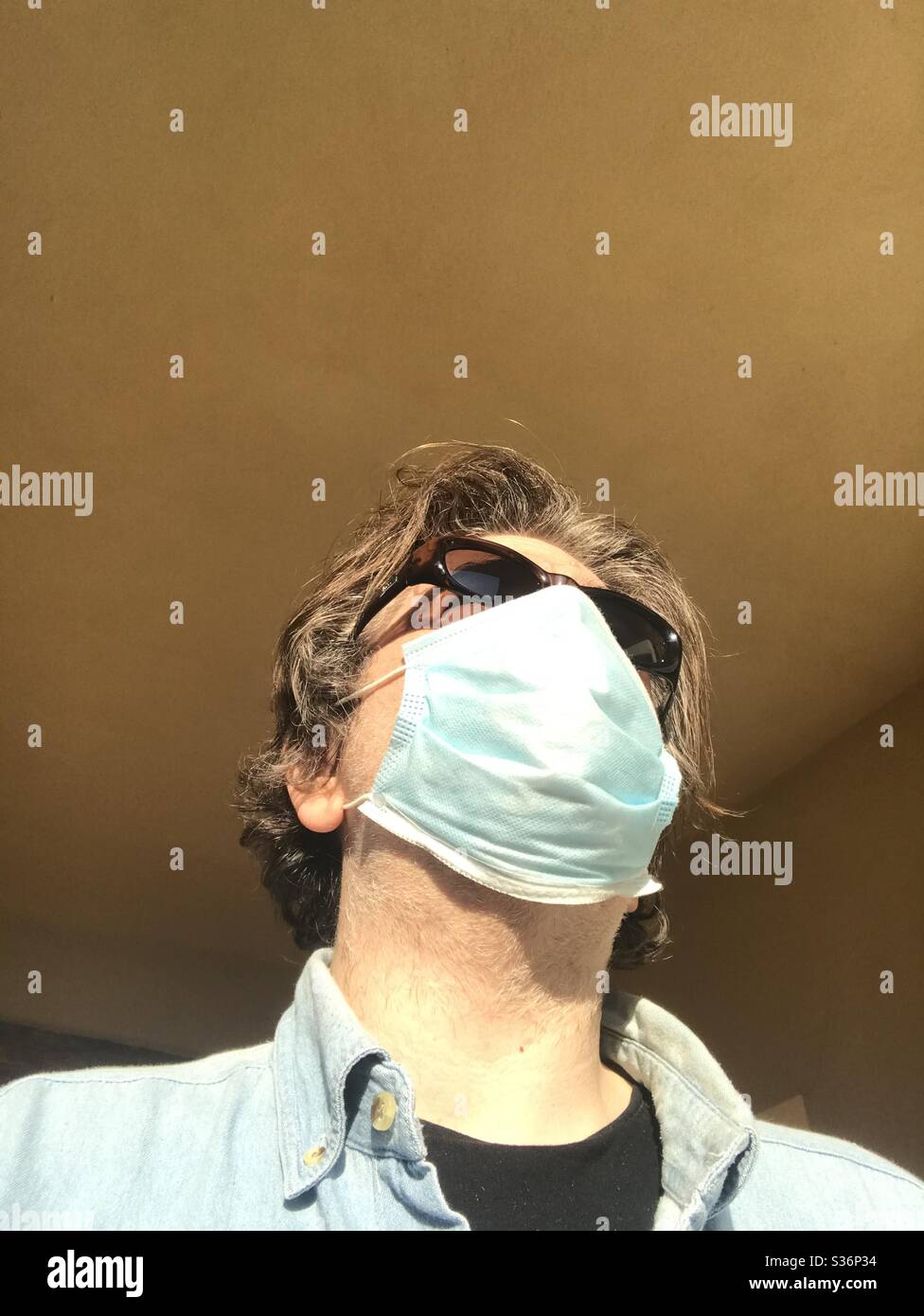 Adult caucasian man wearing face protection mask - Smartphone Captured Stock Image