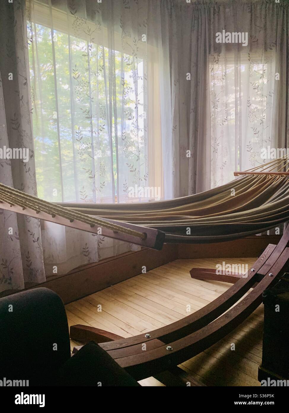 A hammock in a bay window on a sunny summer day. - Smartphone Captured Stock Image