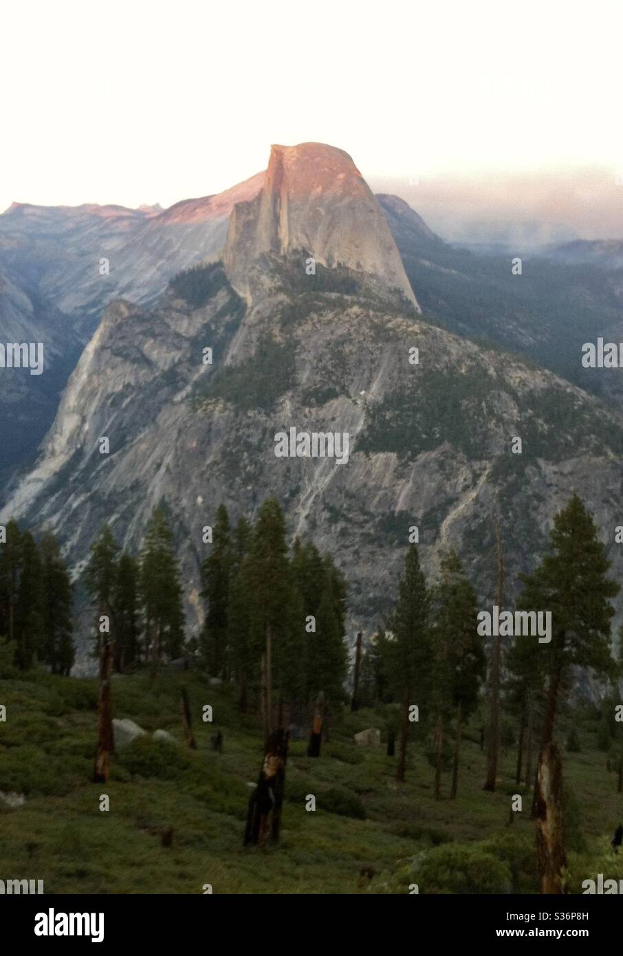Last rays of sunlight on Half Dome, with smoke from bushfires in the background, in Yosemite National Park, California. - Smartphone Captured Stock Image