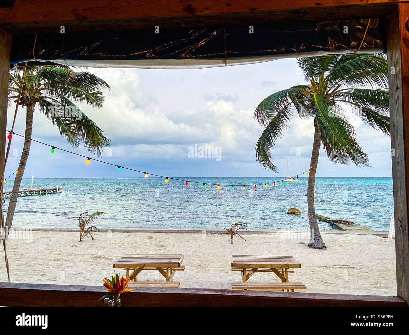 The view of the Caribbean Sea through the window of the Blue Water Grill in San Pedro, Ambergris Caye, Belize on March 13, 2020. - Smartphone Captured Stock Image