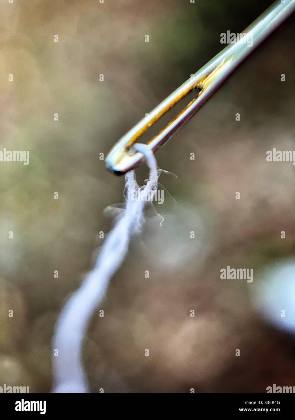 Needle threaded with white thread close up - Smartphone Captured Stock Image