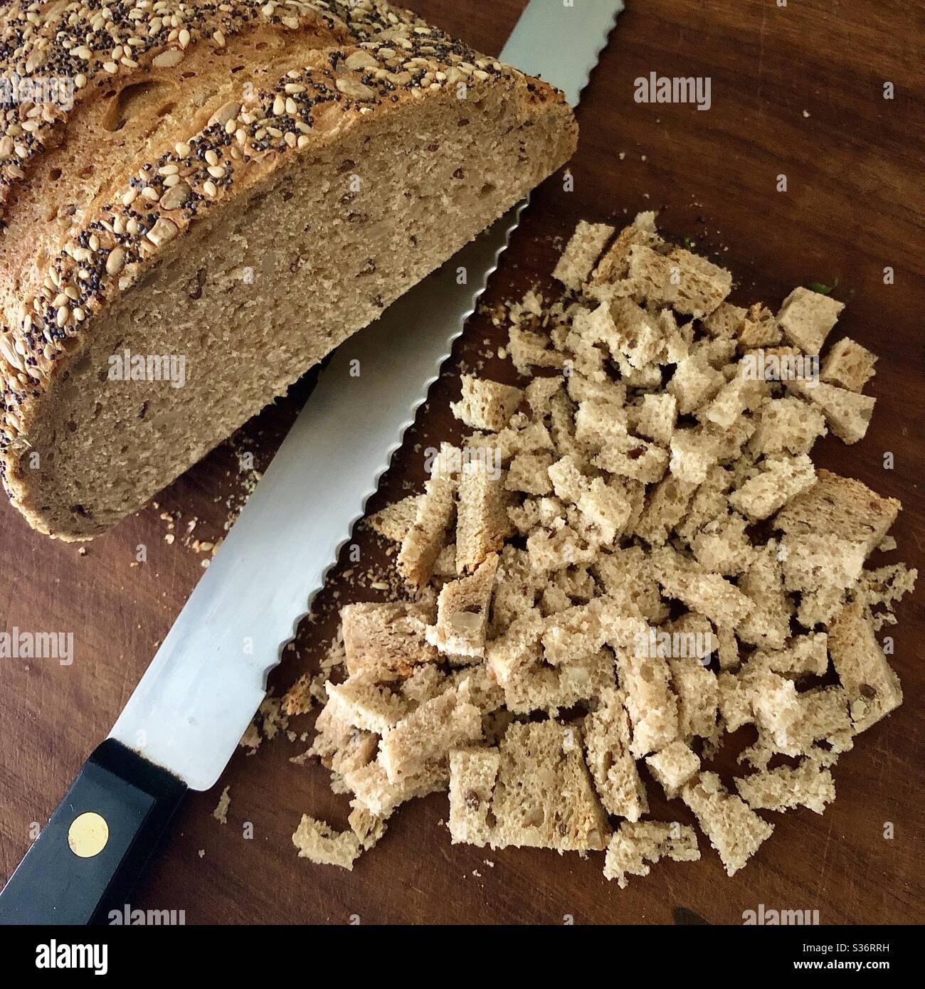 Cutting wholemeal bread for bird food. Stock Photo