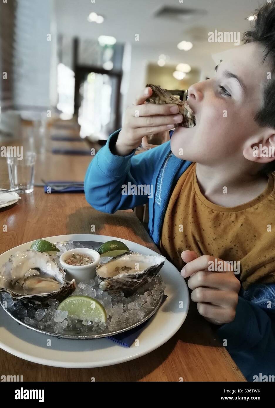 Young boy eating oysters Stock Photo Alamy