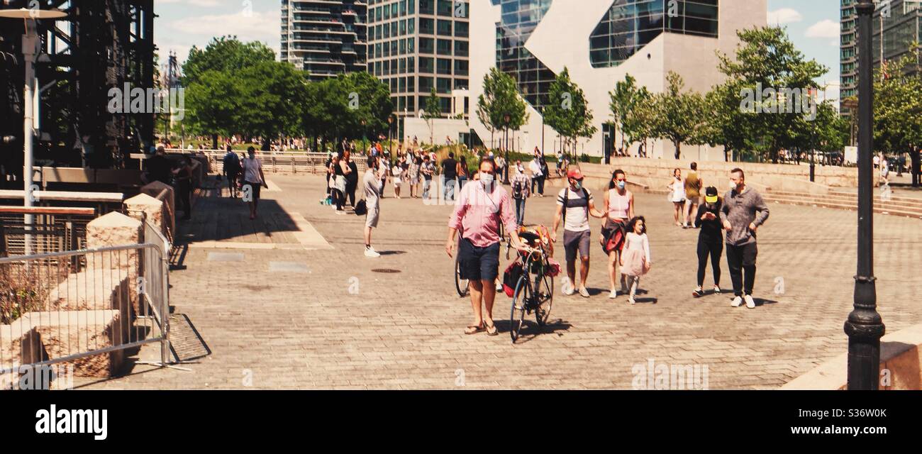 Residents and visitors walking by the Gantry State Park Plaza on one of the first Summer Weekend while NYC is getting ready to go to phase one exit the lock down - Smartphone Captured Stock Image