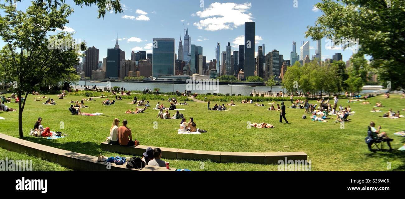 People from the neighborhood and from all over New York City taking advantage of the first weekend of summer to go out to the Gantry State Park, by the East River, after two months of lockdown - Smartphone Captured Stock Image