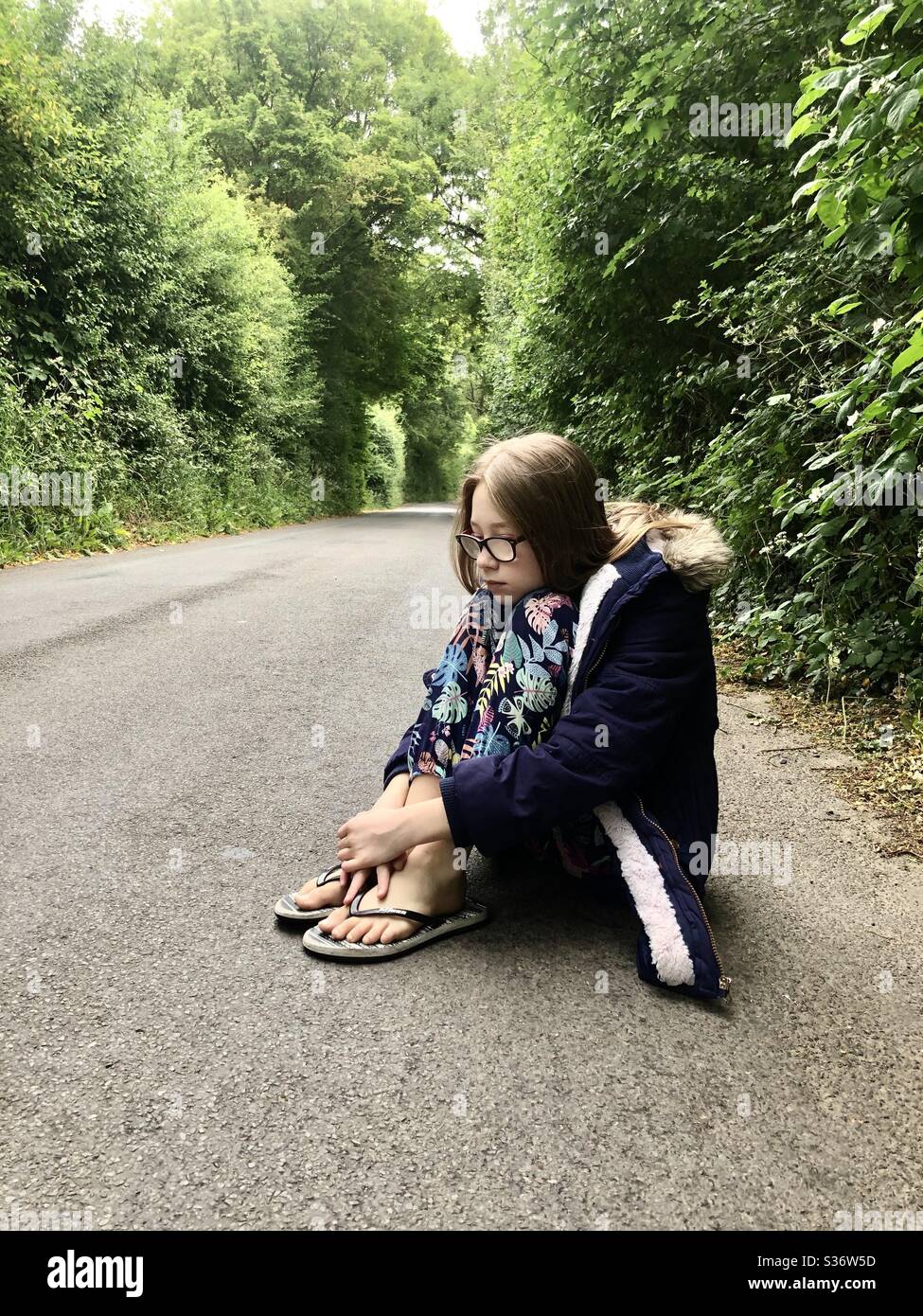 Lonely female child sitting in road - Smartphone Captured Stock Image