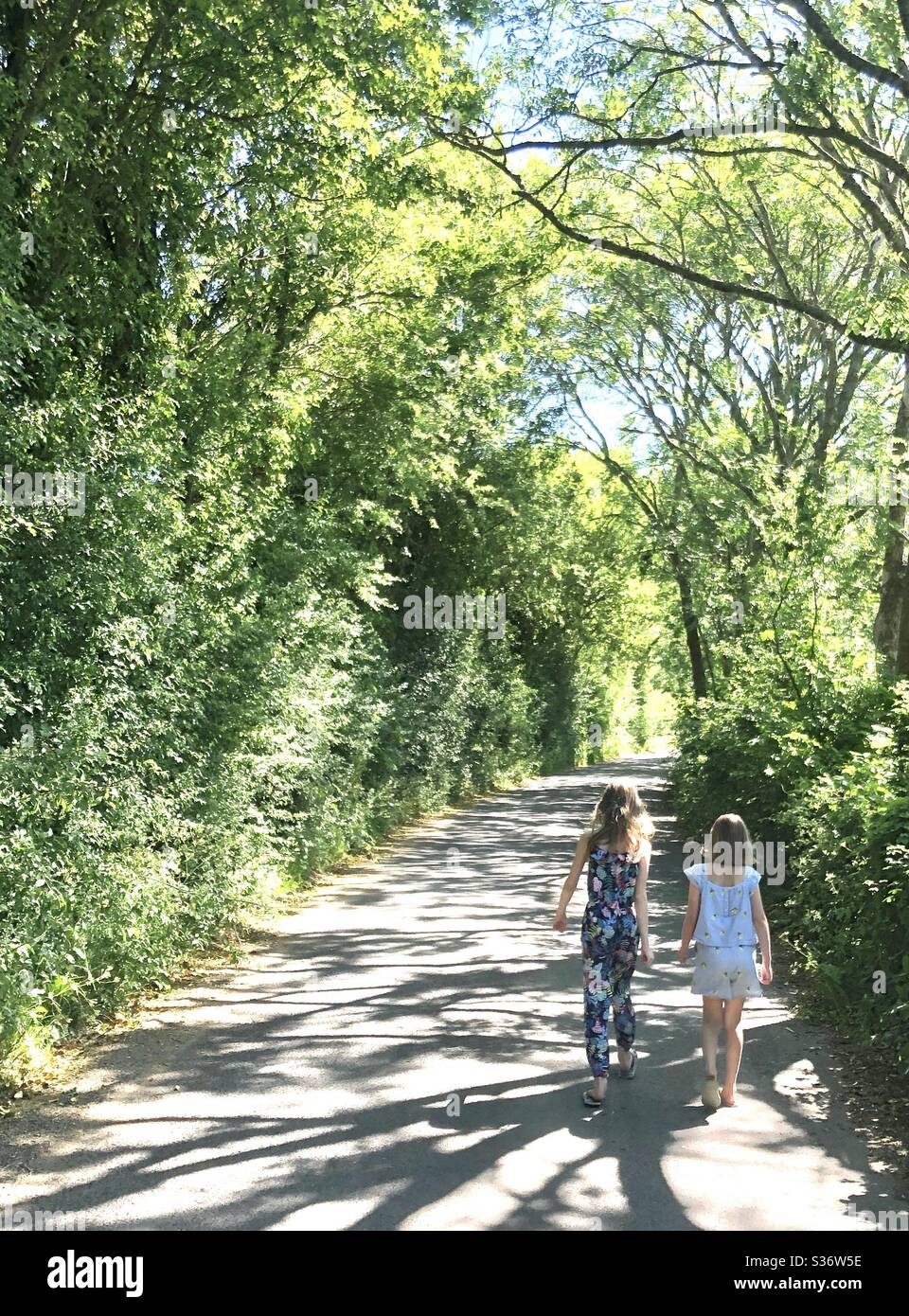 Two sisters walking done a lane - Smartphone Captured Stock Image