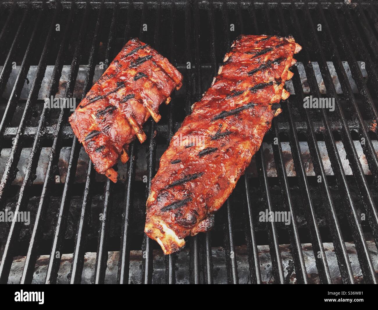 Pork back ribs cooking on BBQ grill Stock Photo