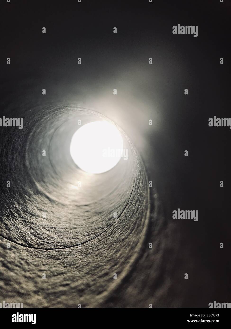 Dramatic Sun view through a spiral empty tissue roll  , imagination for ray of hope Stock Photo