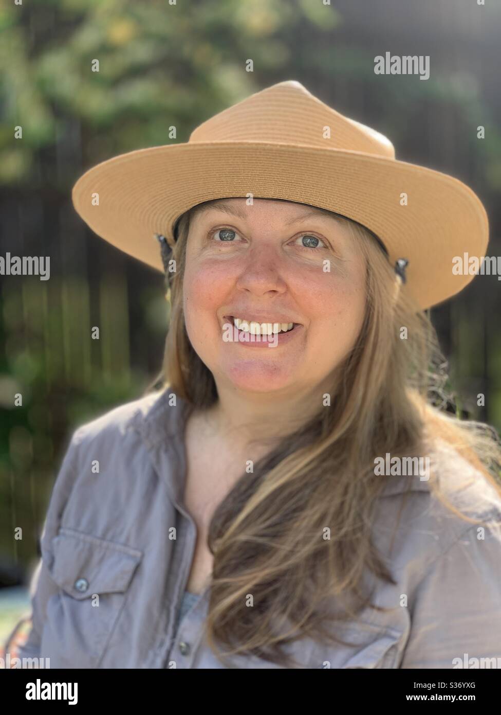 Smiling blonde woman with ranger hat , hiking - Smartphone Captured Stock Image