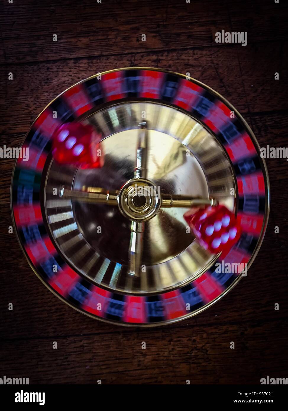 Rolling the dice, literally. Two dice showing the numbers six and three on a spinning base. Concepts: changing luck, fluidity, moving, luck of the draw, risk taking - Smartphone Captured Stock Image