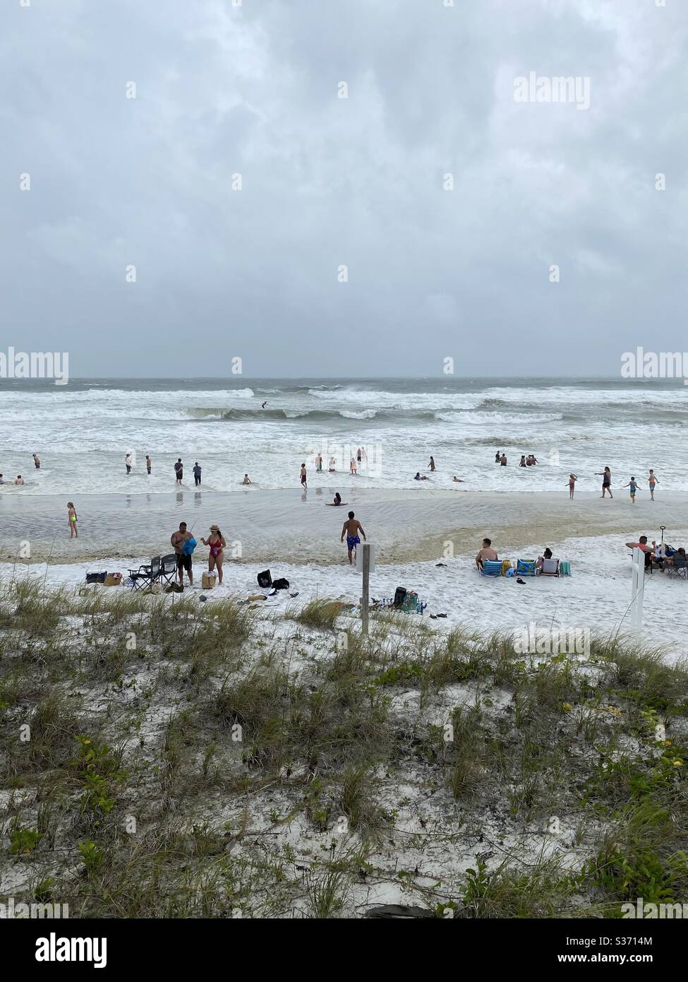 Large crowd of people remain on the beach as tropical storm Cristobal arrives on the Emerald Coast June 7, 2020 Stock Photo