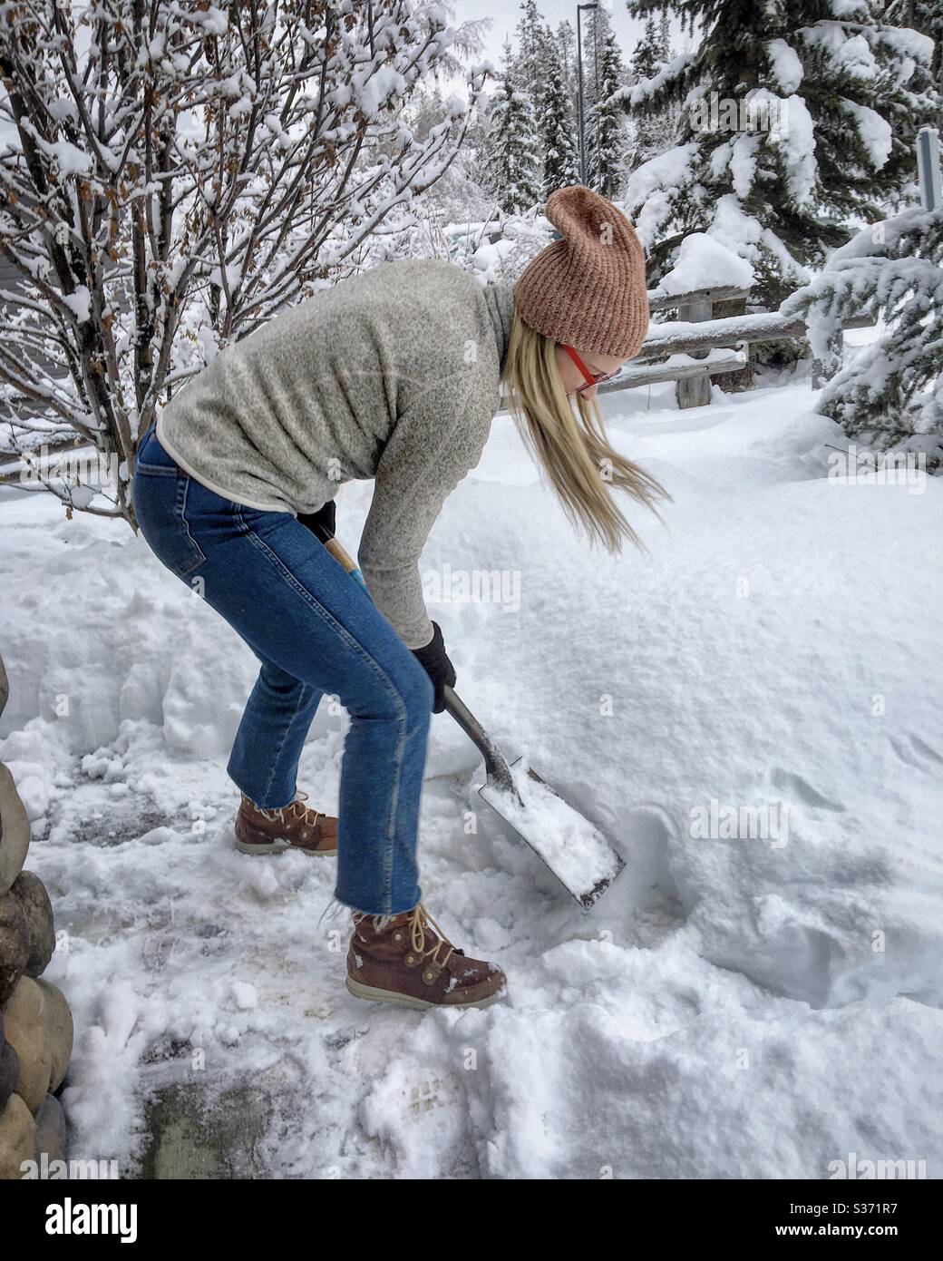 Woman shoveling snow in Canmore. Alberta Canada December 2019 Stock Photo Alamy