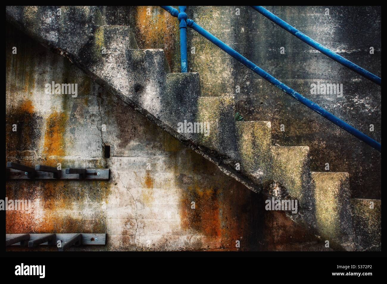 Weathered concrete staircase with blue banister - Smartphone Captured Stock Image
