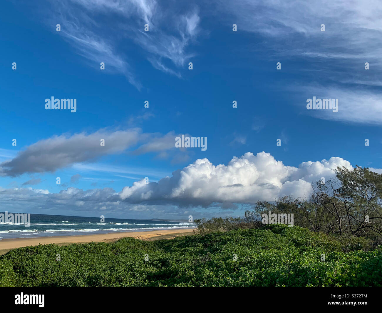 Blue sky, ocean, beach and white fluffy cumulus clouds and other different types - Smartphone Captured Stock Image