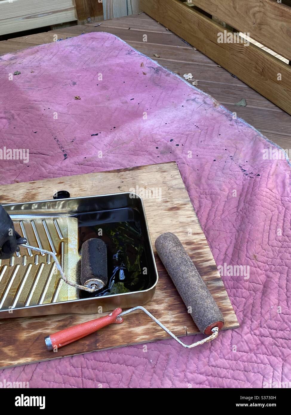 Equipment to stain deck with rollers pan and oil based stain Stock