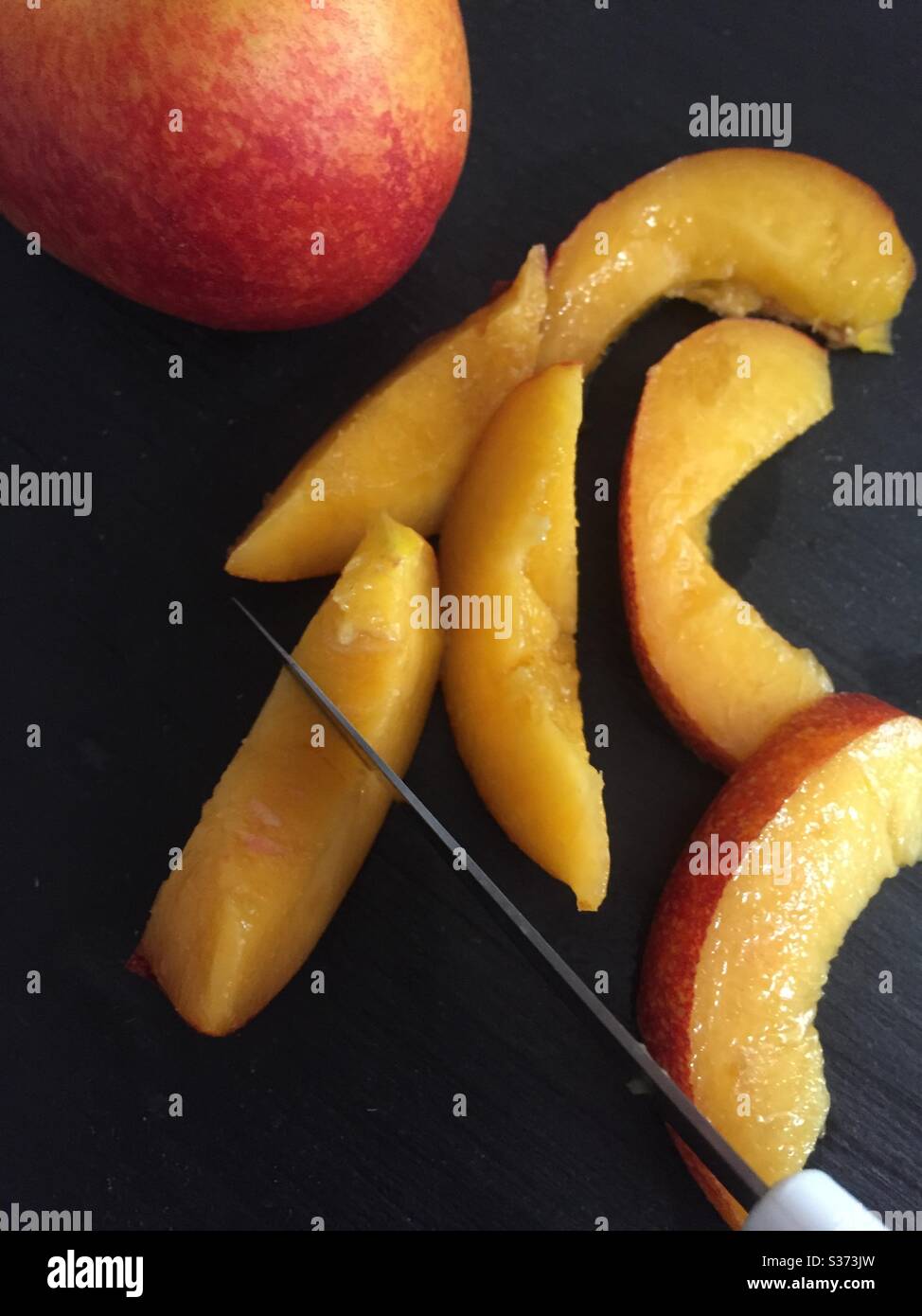 Cutting slice of nectarine Stock Photo Alamy