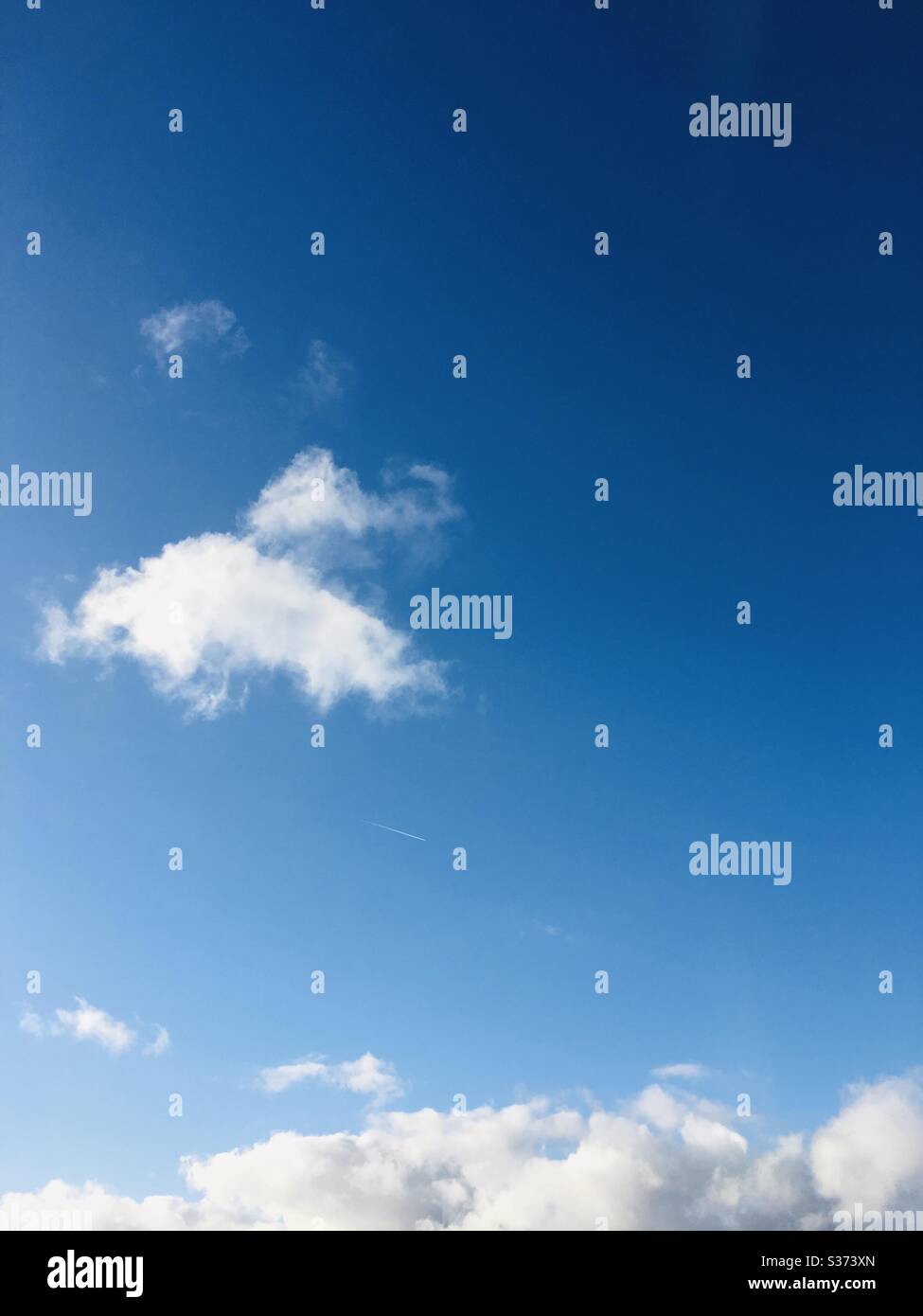 White clouds in a clear blue sky - Smartphone Captured Stock Image