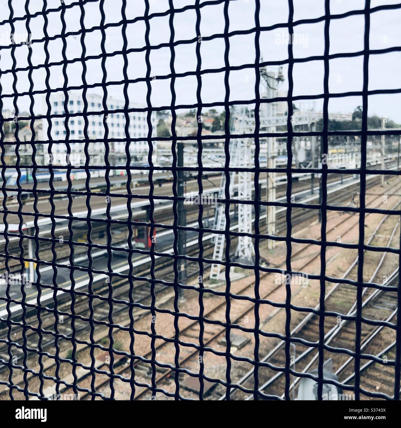 Wire mesh grill on footbridge above railway tracks at Poitiers station, Vienne, France. Stock Photo