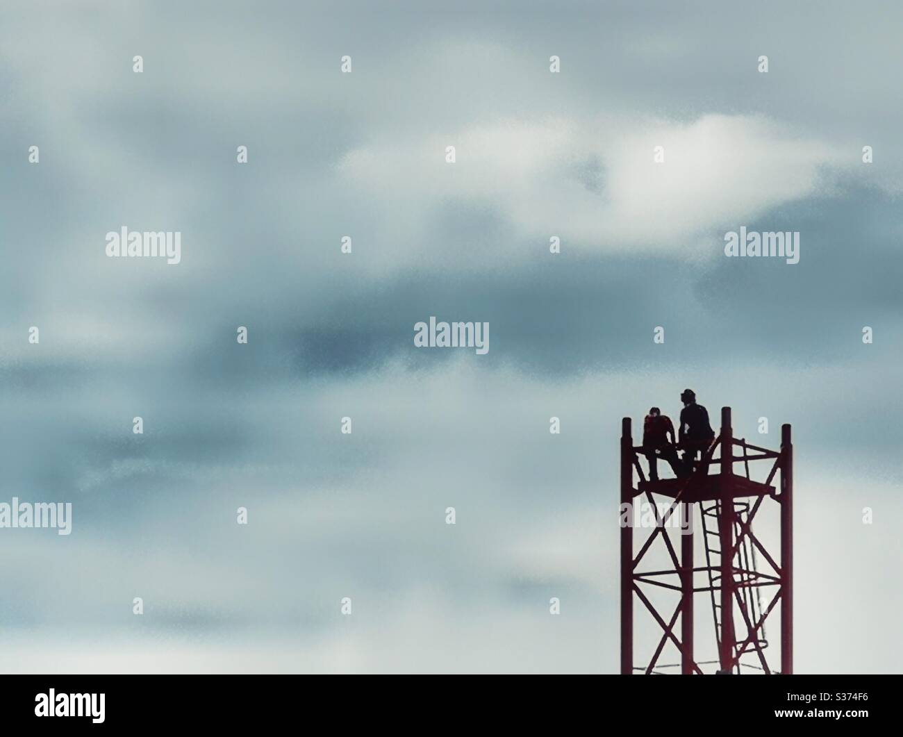 Men atop partially built crane tower - Smartphone Captured Stock Image