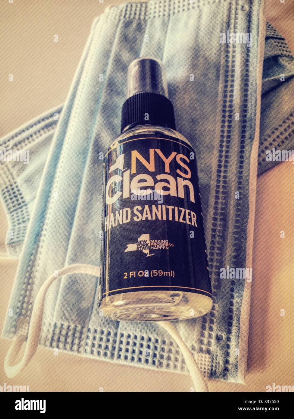 Hand sanitizer spray bottles and protective face masks are being given away by New York State to its residents during the COVID-19 pandemic, 2020, USA - Smartphone Captured Stock Image