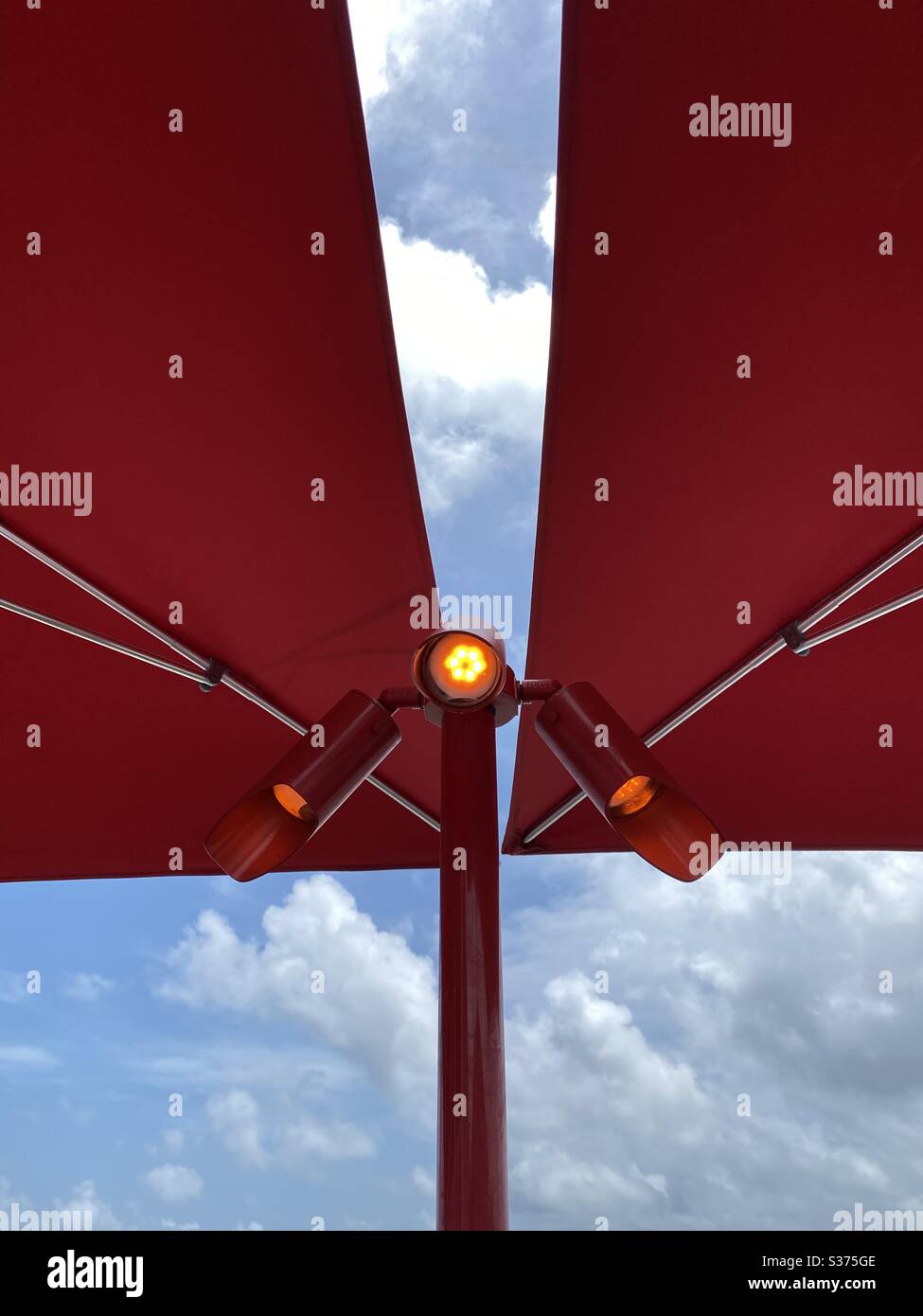 Red outdoor umbrella with light fixture underneath the umbrellas Stock Photo Alamy