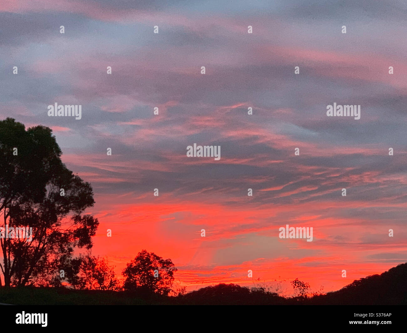 Hot pink sky at sunset on a winters evening in Aus Stock Photo