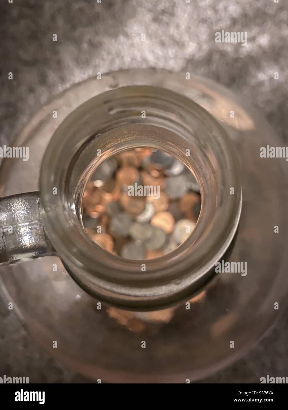 Coins in glass jug Stock Photo