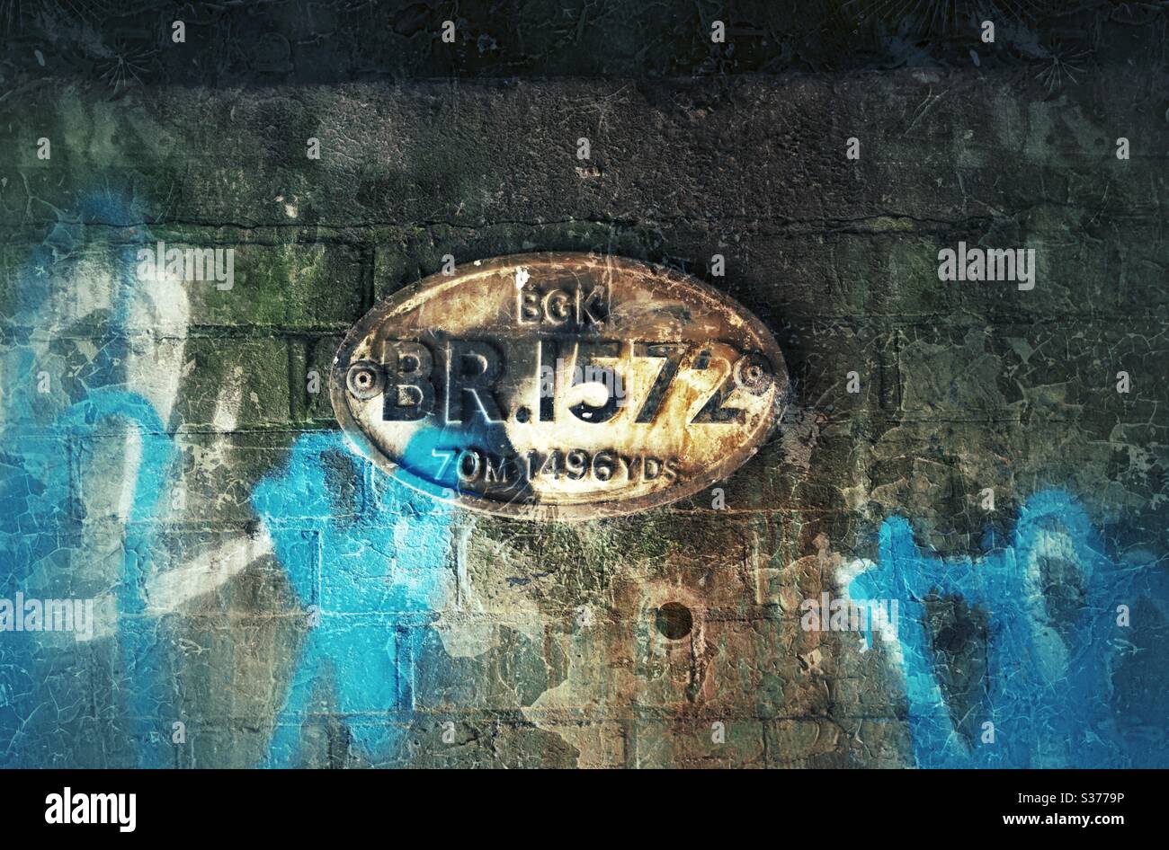 Badge from canal bridge on a brick wall with graffiti - Smartphone Captured Stock Image